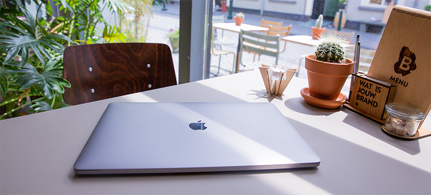 Laptop ligt op tafel in een café